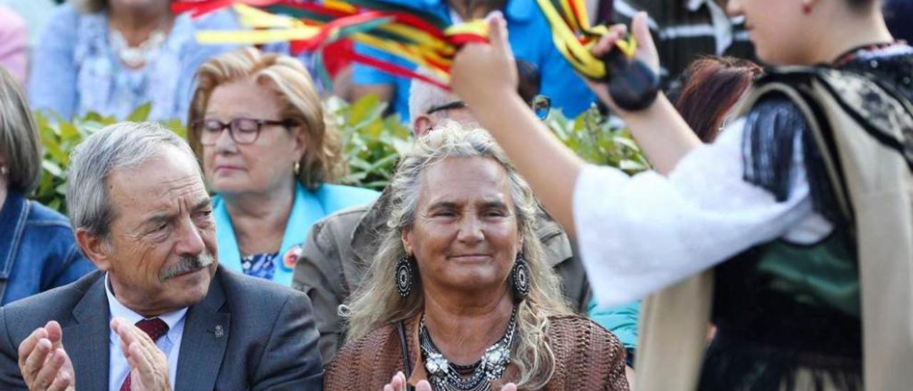 Una de las integrantes del grupo de baile llanisco bailando el Pericote ante el alcalde de Oviedo, Wenceslao López, y su esposa, Azucena Álvarez, durante el desfile del Día de América en Asturias.