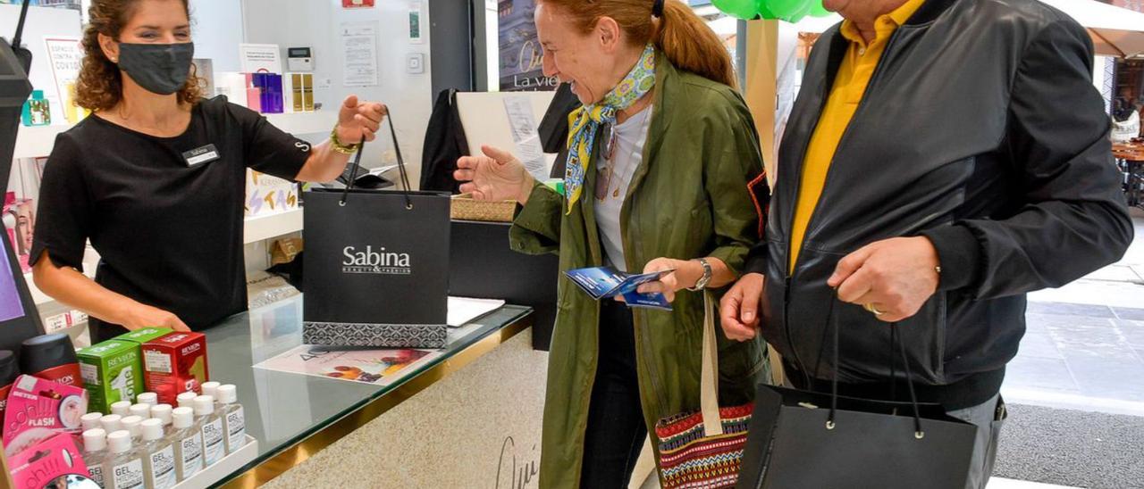 Dos turistas compran algunos artículos en una perfumería de la capital grancanaria.  | | JUAN CASTRO