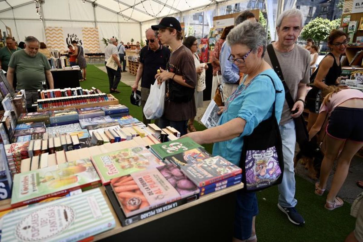 Visitantes de la Festa dos Libros en uno de los puestos de las 13 librerías participantes. | // RAFA VÁZQUEZ