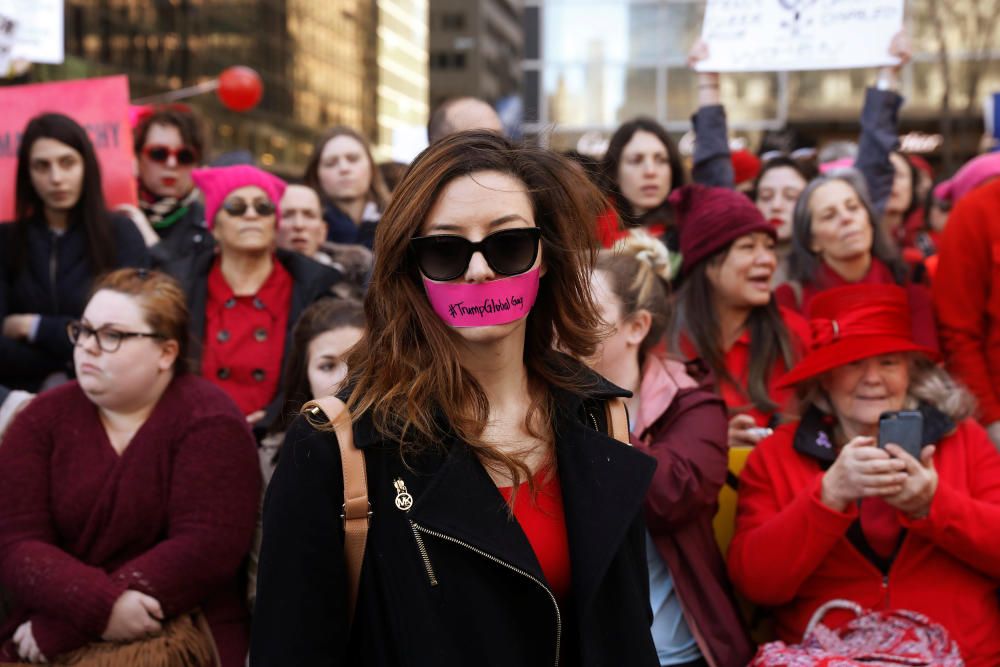 A woman with tape over her mouth takes part in a ...