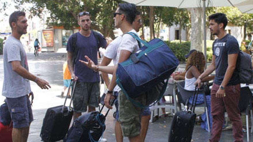 Viajeros con sus maletas en la plaza de España. El alquiler turístico hace que sea cada vez más habitual ver esta escena en barrios de Palma y zonas sin apenas hoteles.