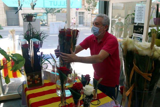 El florista i president del gremi que els agrupa, Joan Guillén, arregla flors al seu establiment mentre espera clients aquest Sant Jordi d'estiu.