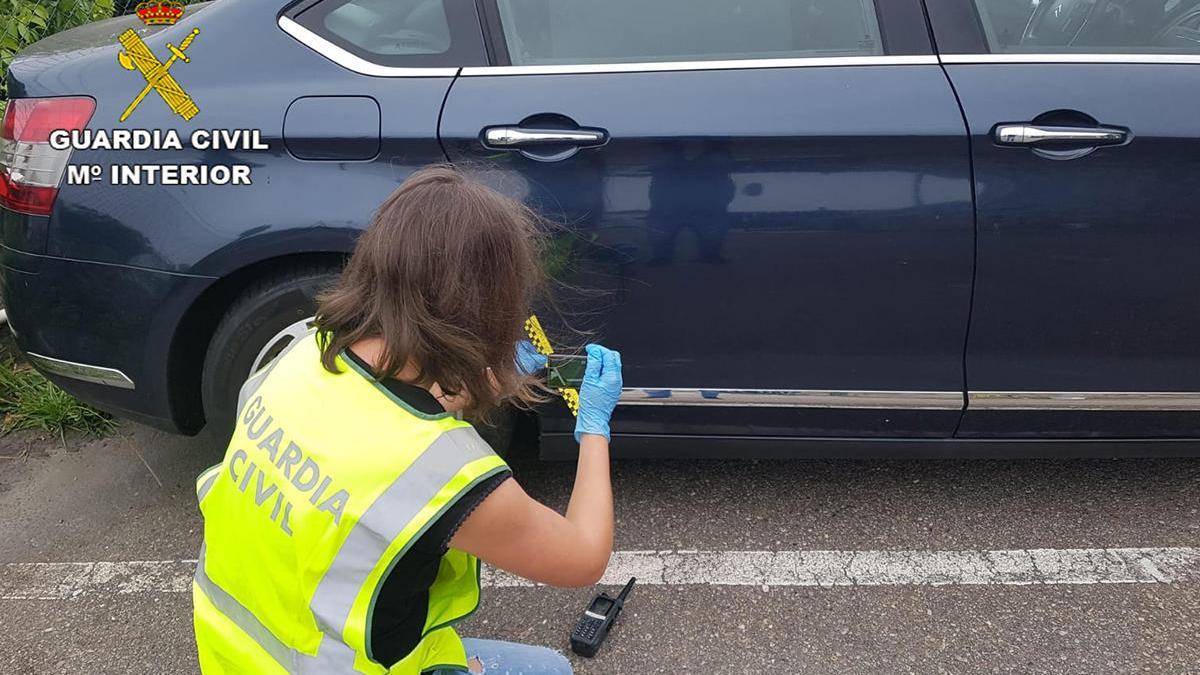 Una guardia civil inspecciona uno de los vehículos dañados // FdV