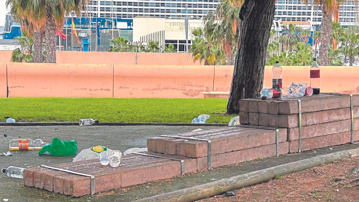 La zona de la Muralla del Mar llena de basura tras un botellón nocturno, de fondo un crucero hace escala en la ciudad.