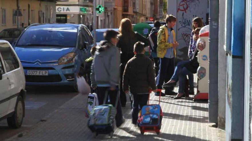 Varios escolares zamoranos salen del colegio con sus mochilas.
