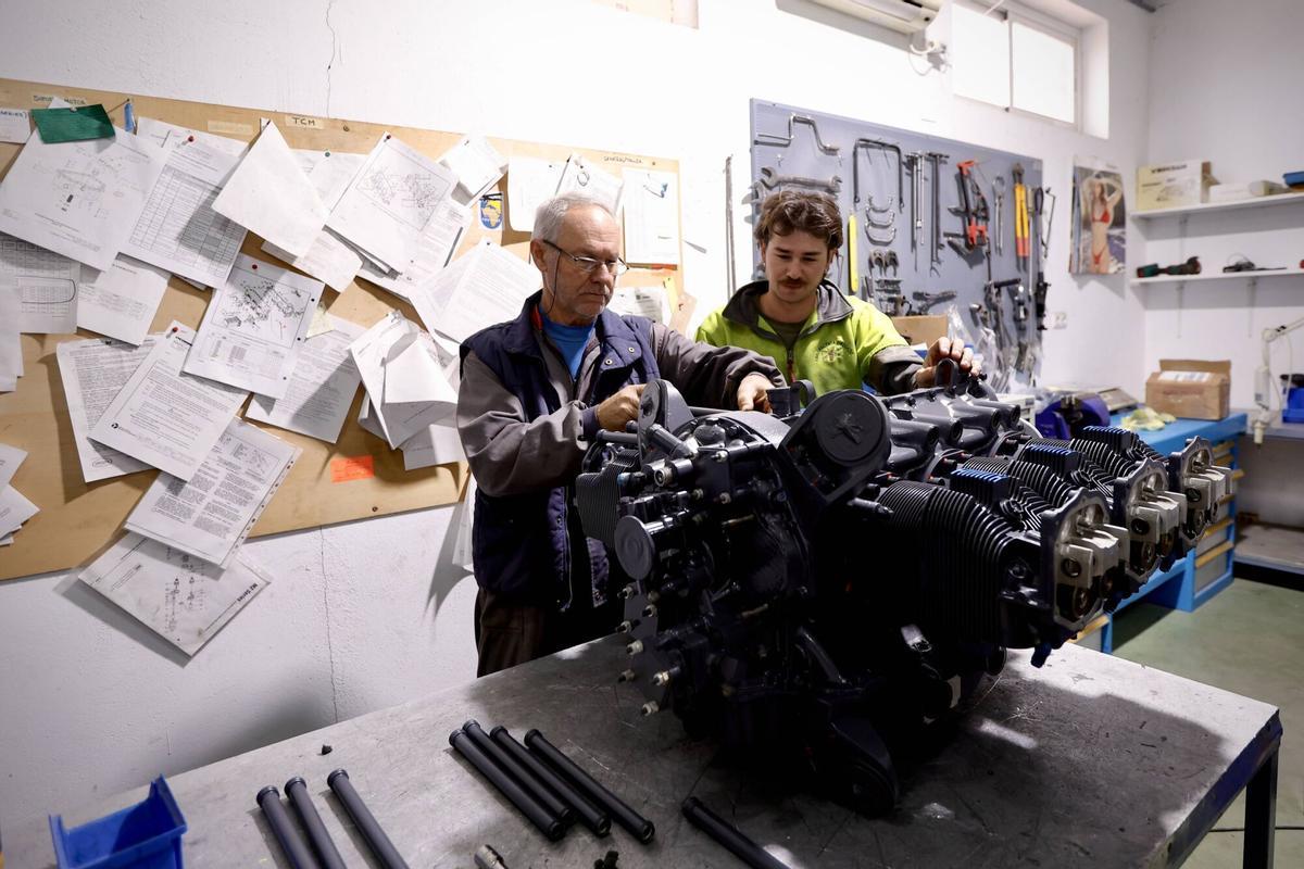 Rafael Delgado (i) repara un motor de una aeronave.