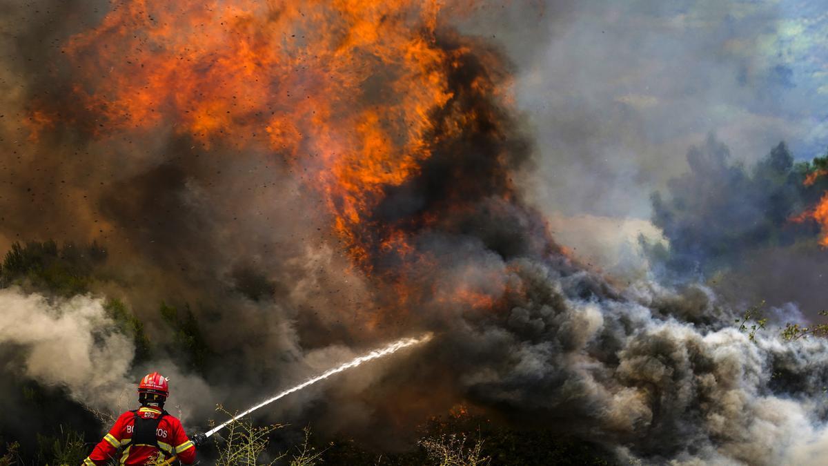 Un bombero combate las llamas que rodean el pueblo de Ancede durante un incendio forestal en el municipio de Baiao, norte de Portugal, el 15 de julio de 2022.