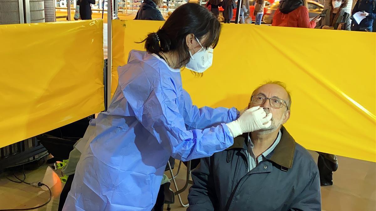 Pla mitja d una persona fent un test rapid d antigens en un dels punts de cribratge de la Cambra de Comerc de Barcelona  Imatge del 22 de desembre de 2020 (Horitzontal) Marta Casado Pla ACN
