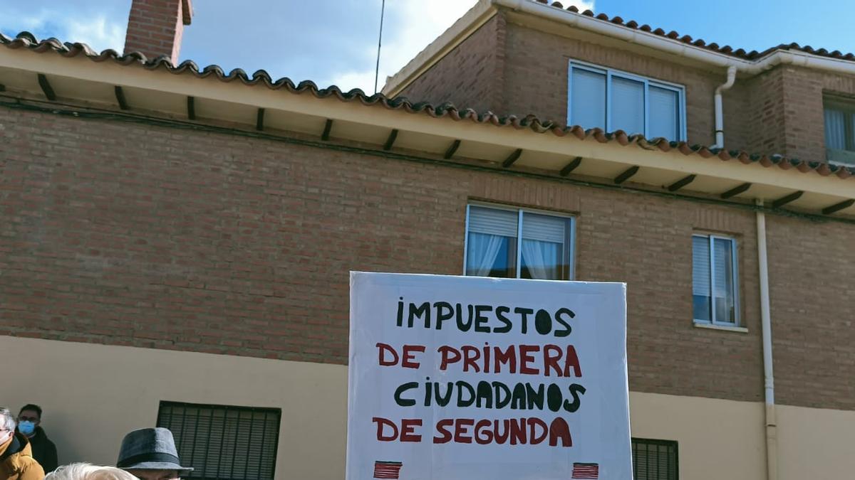 &quot;Impuestos de primera, ciudadanos de segunda&quot;, lema en una pancarta con las banderas de Zamora en la manifestación por la sanidad rural en Vezdemarbán.