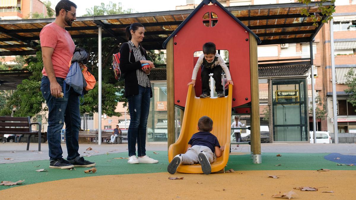 Unos padres de Sant Boi disfrutan de las nuevas instalaciones de la Plaça Catalunya de la ciudad.