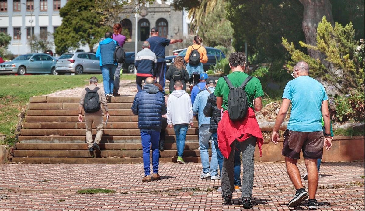 Varias personas pasean por el jardín de Edificio Central de la ULL.