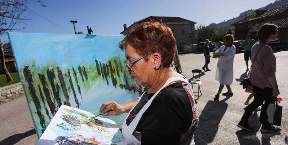 Pintor y caballete con hórreo al fondo