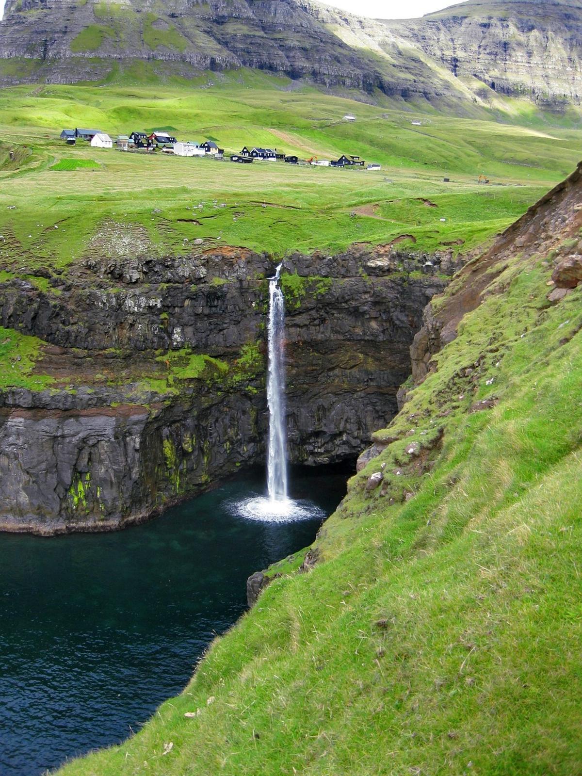 La cascada de Gásadalur, con la aldea al fondo.