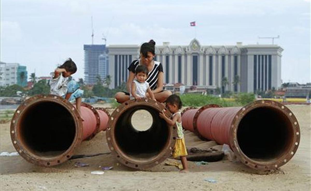 Una família juga a les canonades per bombar sorra que s’estan utilitzant per omplir el llac Boeung Kak, a Phnom Penh (Cambodja).