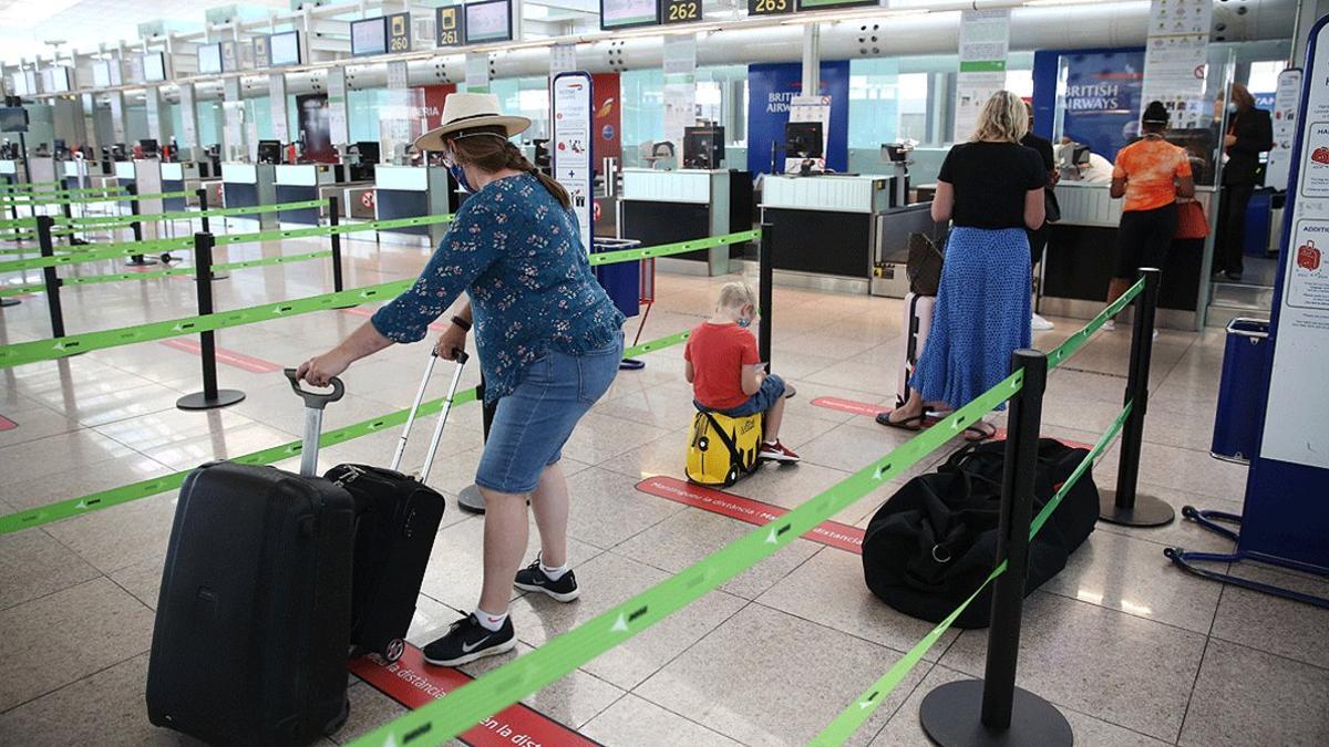 Una familia de turistas británicos, en el aeropuerto de El Prat, a punto de volar de regreso a Londres, este lunes 27 de julio