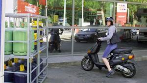 zentauroepp152443 a woman riding a scooter stops at a gas station which announ200518095407