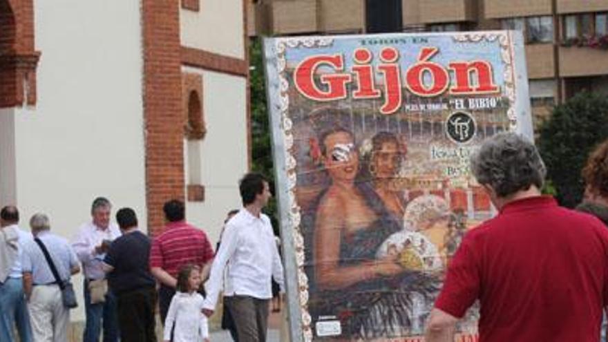 Un paseante contempla el cartel de la feria de Begoña, con las colas en la taquilla al fondo.