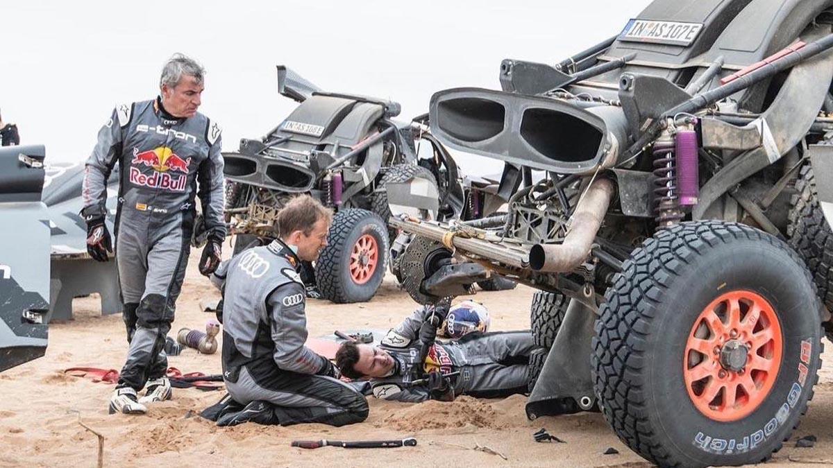 Carlos Sainz mira los desperfectos de su coche tras un accidente en una etapa del Dakar 2023.