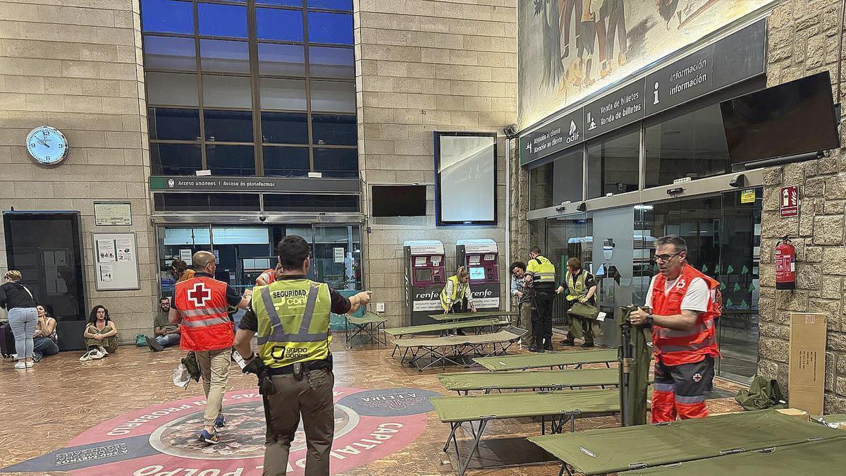 Voluntarios de Cruz Roja instalan material para personas afectadas durante el apagón del año pasado en la estación de tren ADIF