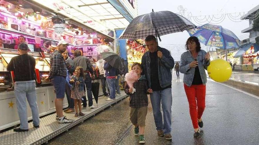 Un grupo de visitantes pasea por las atracciones de la feria, tras su inauguración.