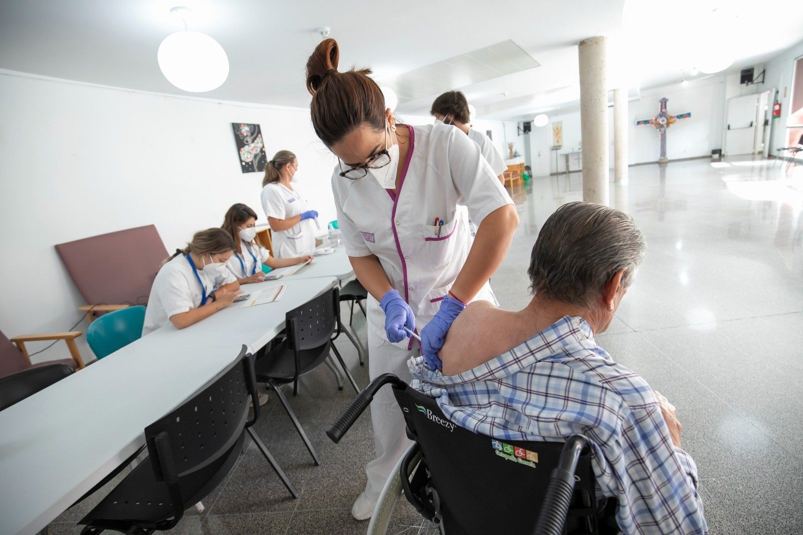 Una sanitaria inoculando a una persona con la vacuna contra la COVID.