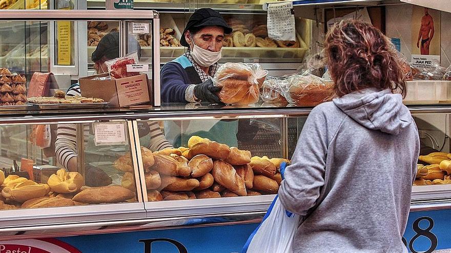 Una trabajadora atiende a una clienta en una pandería.