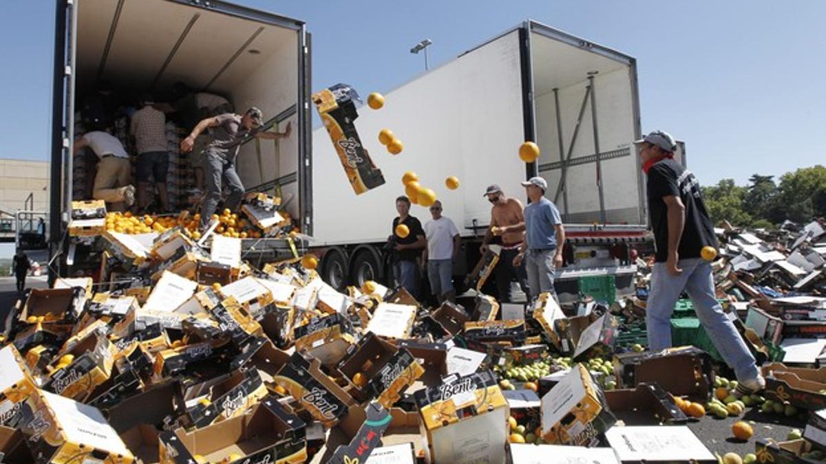 Agricultores franceses destruyen la carga de un camión español que transporta fruta y verduras.
