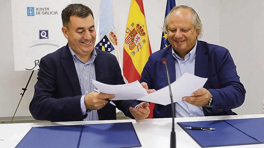 El conselleiro Román Rodríguez y Miguel Mirones, del ICTE, en la firma del convenio. // FdV