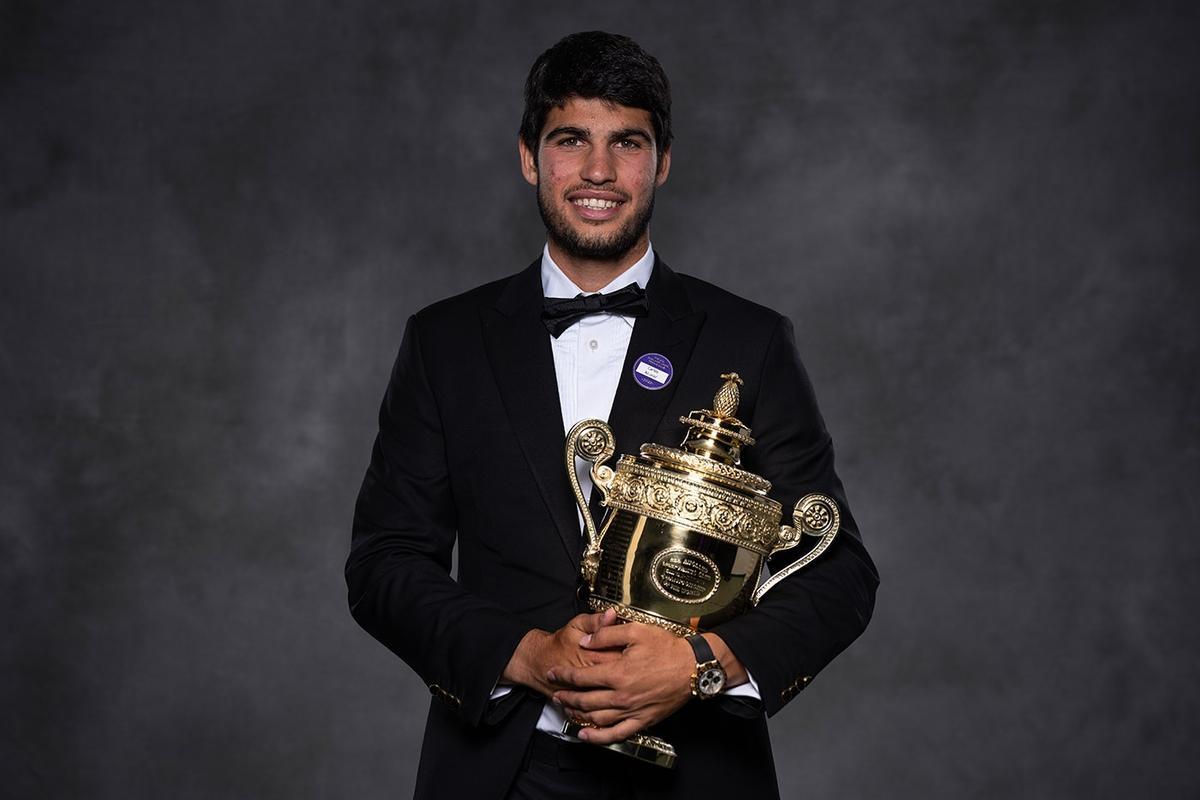 Carlos Alcaraz, de etiqueta posando con el trofeo de su primer Wimbledon.