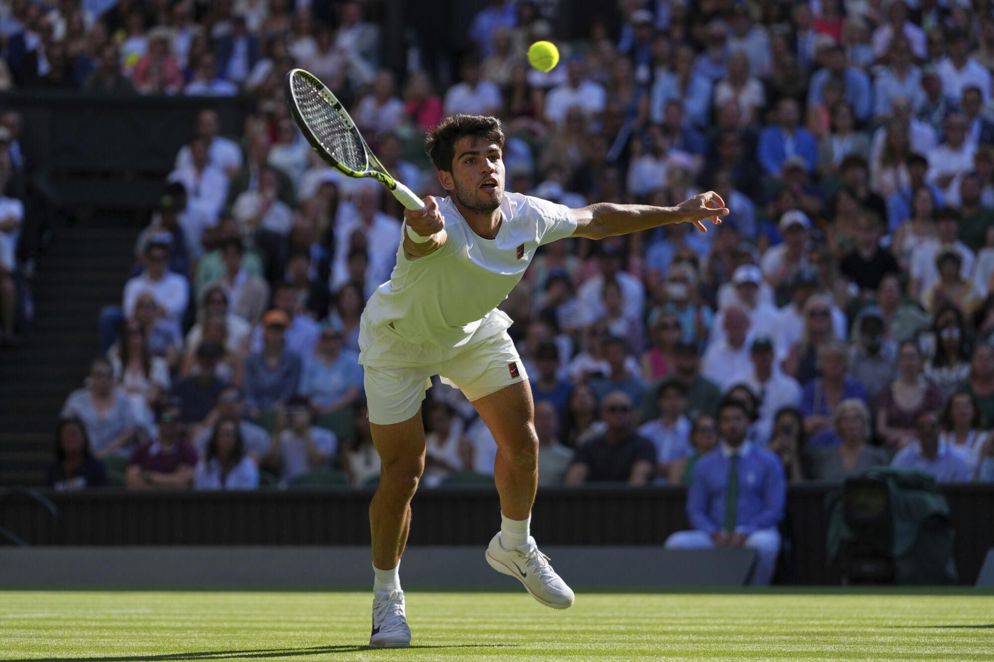 Spain's Carlos Alcaraz returns to Britain's Cameron Norrie during a quarterfinal men's singles match at the Wimbledon Tennis Championships in London, Tuesday, July 8, 2025. (AP Photo/Kirsty Wigglesworth)