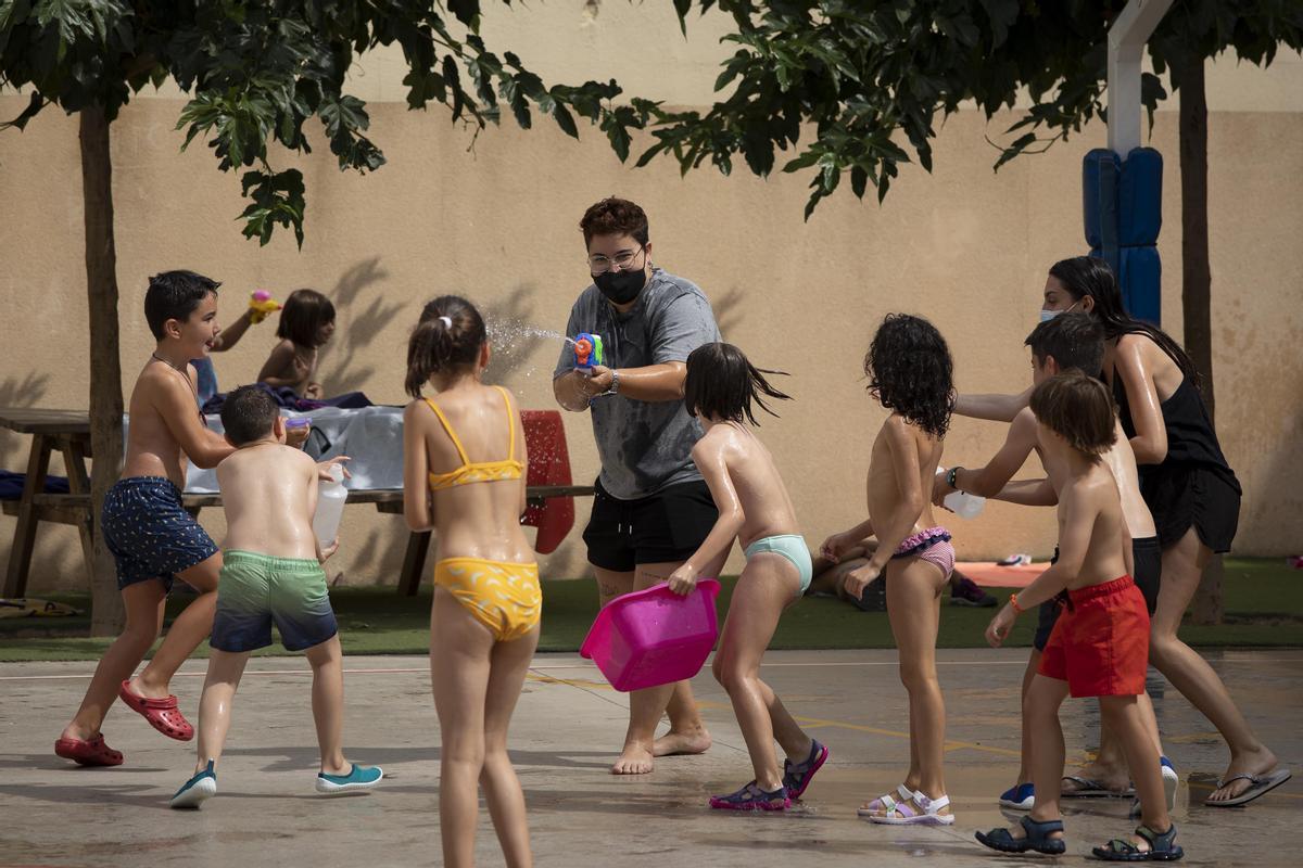 Niños tratando de zafarse de una monitora armada con una pistola de agua, en la escuela Fedac, el pasado viernes