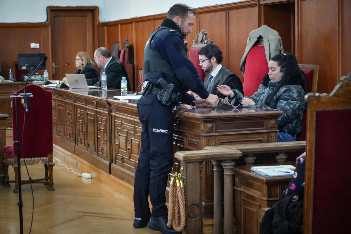 La acusada, mientras un agente de la Policía Nacional le quita las esposas, durante el juicio en la Audiencia Provincial de Badajoz.