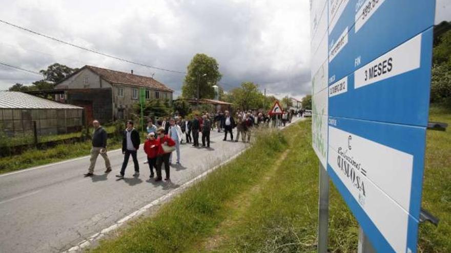 Los participantes en la marcha, el pasado domingo, pasan junto al cartel de la obra.  // Bernabé/Gutier