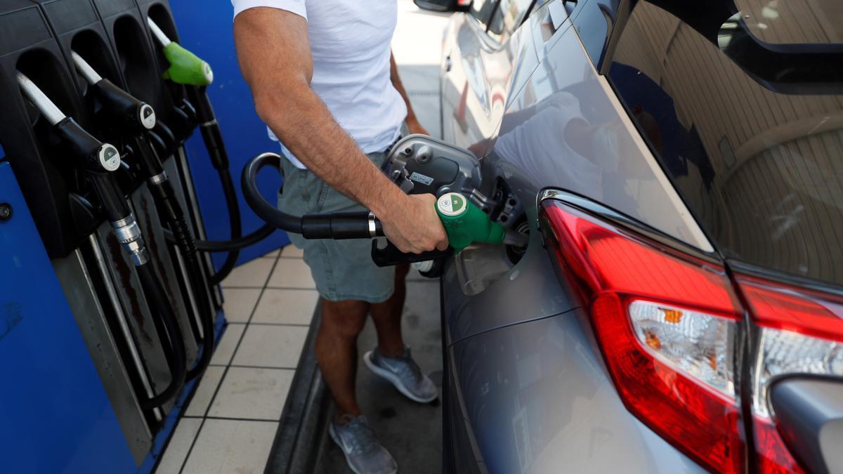 Imagen de archivo de un hombre repostando en una gasolinera.