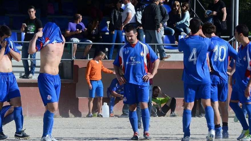 Los futbolistas del Domaio, desolados sobre el terreno de juego de San Adrián. // Gonzalo Núñez