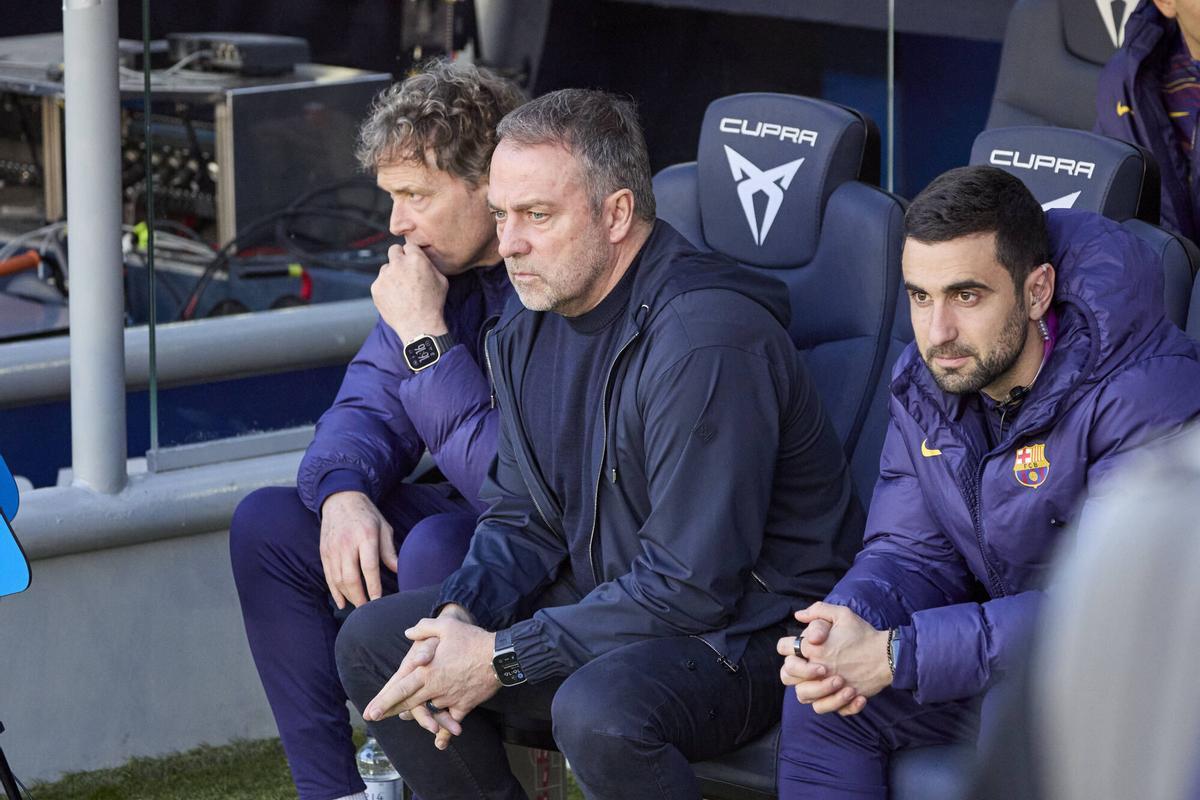 Hansi Flick (c) sentado en el banquillo del Spotify Camp Nou entre Marcus Sorg (c) y Arnau Blanco
