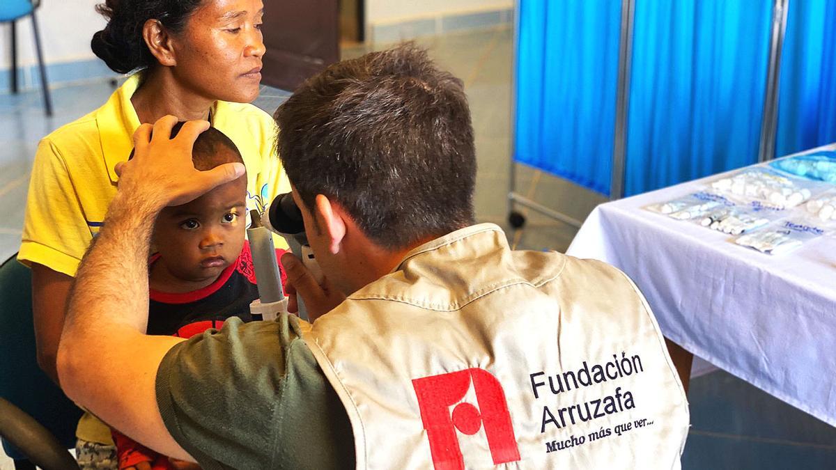 Un oftalmólogo de la Fundación Arruzafa revisa la visión de un niño.