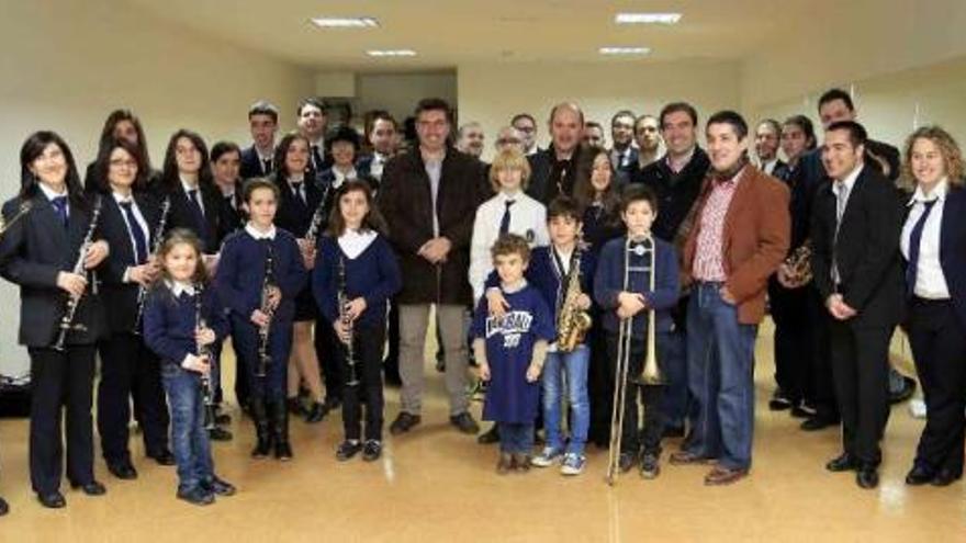 Javier Bas y Rafael Louzán, con los miembros de la banda de música en el nuevo local de Chapela. // Faro