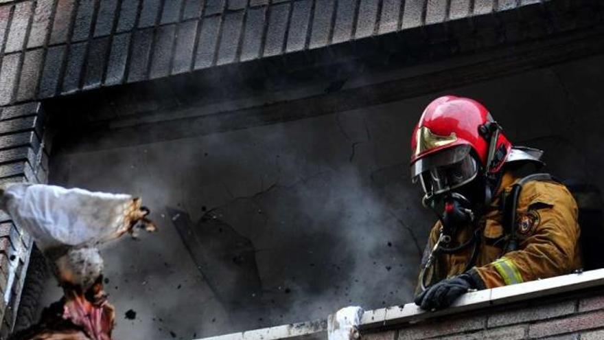 Un bombero interviene en el incendio del edificio de la plaza de Ravella.  // Iñaki Abella