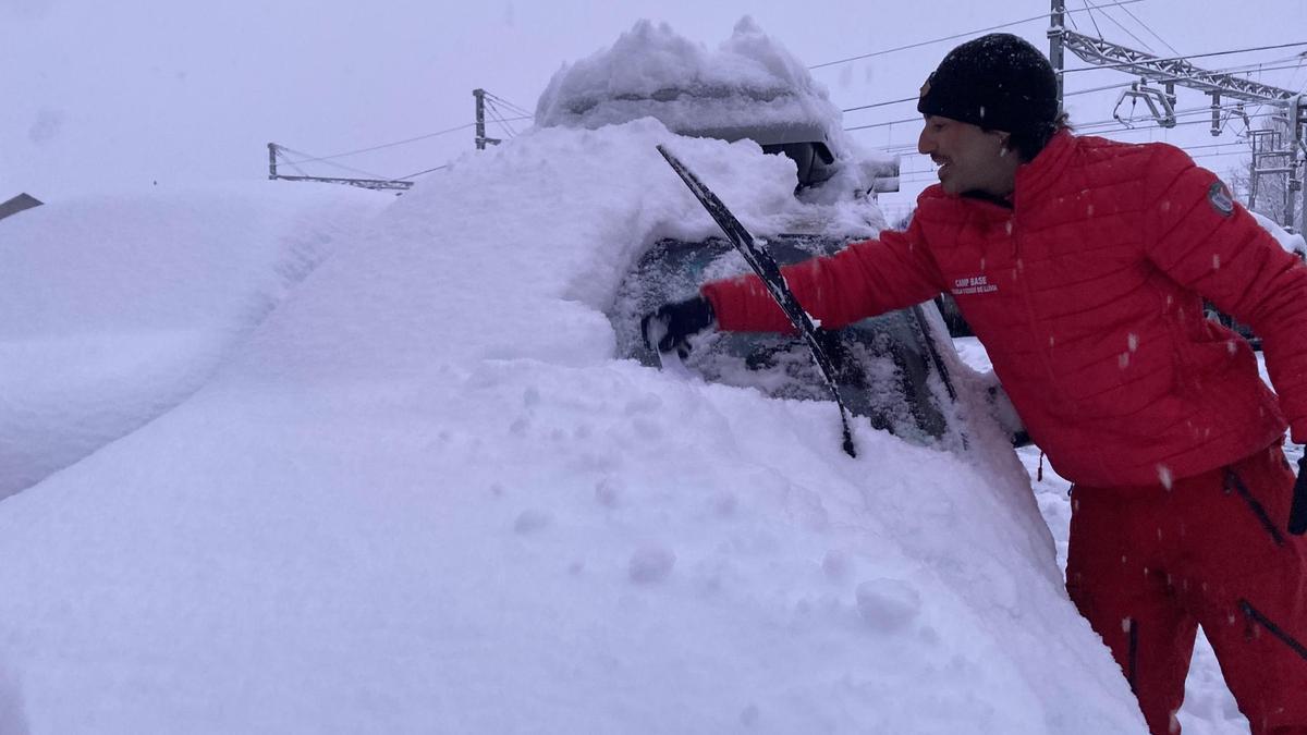 Un conductor neteja la neu del vehicle a Puigcerdà aquest matí
