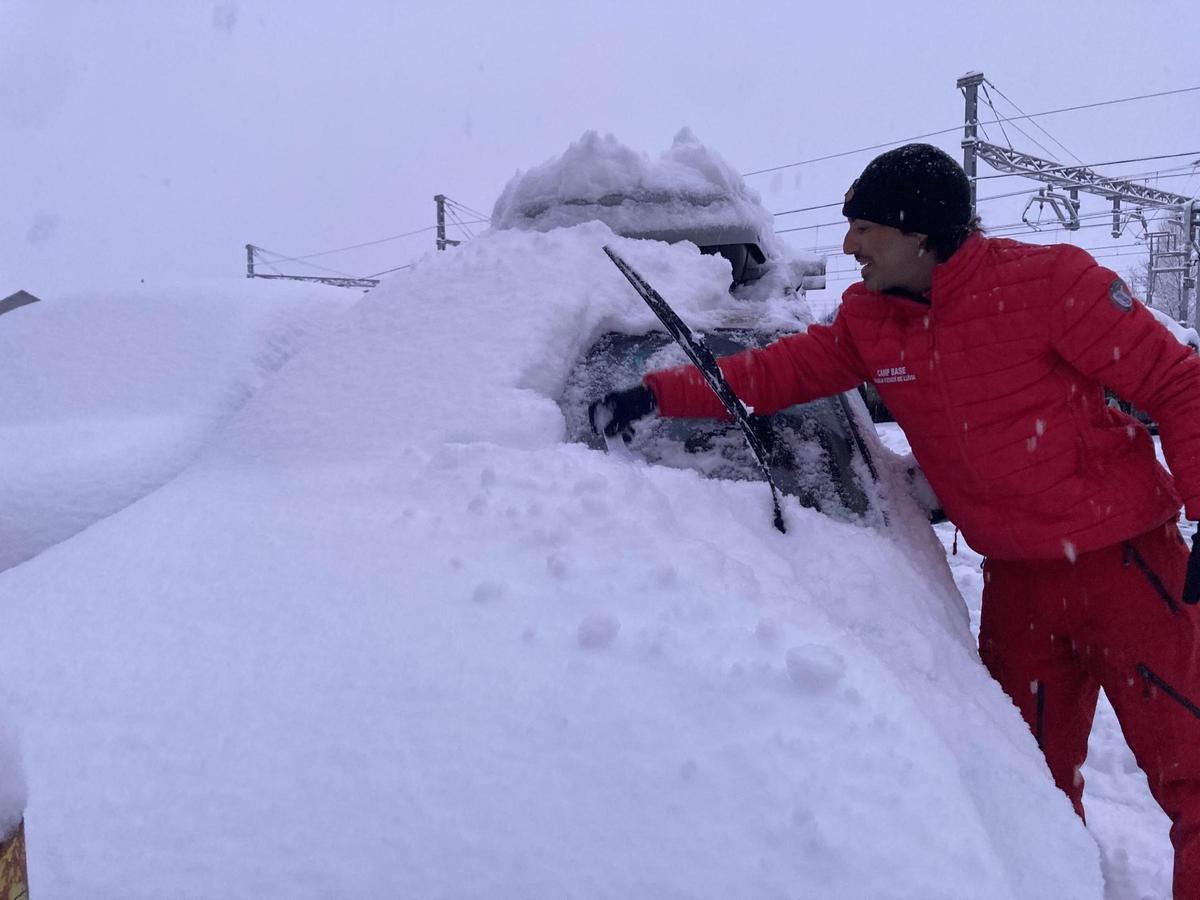 Un conductor neteja la neu del vehicle a Puigcerdà aquest matí