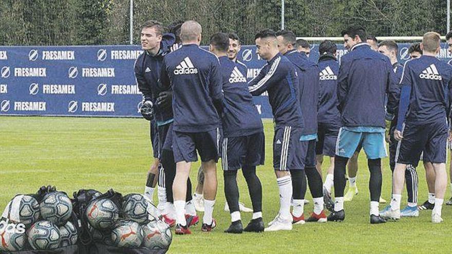 La plantilla del Oviedo, haciendo el pasillo ayer a Lunin, antes del entrenamiento. En el detalle, la tarta con la que celebró su cumpleaños.