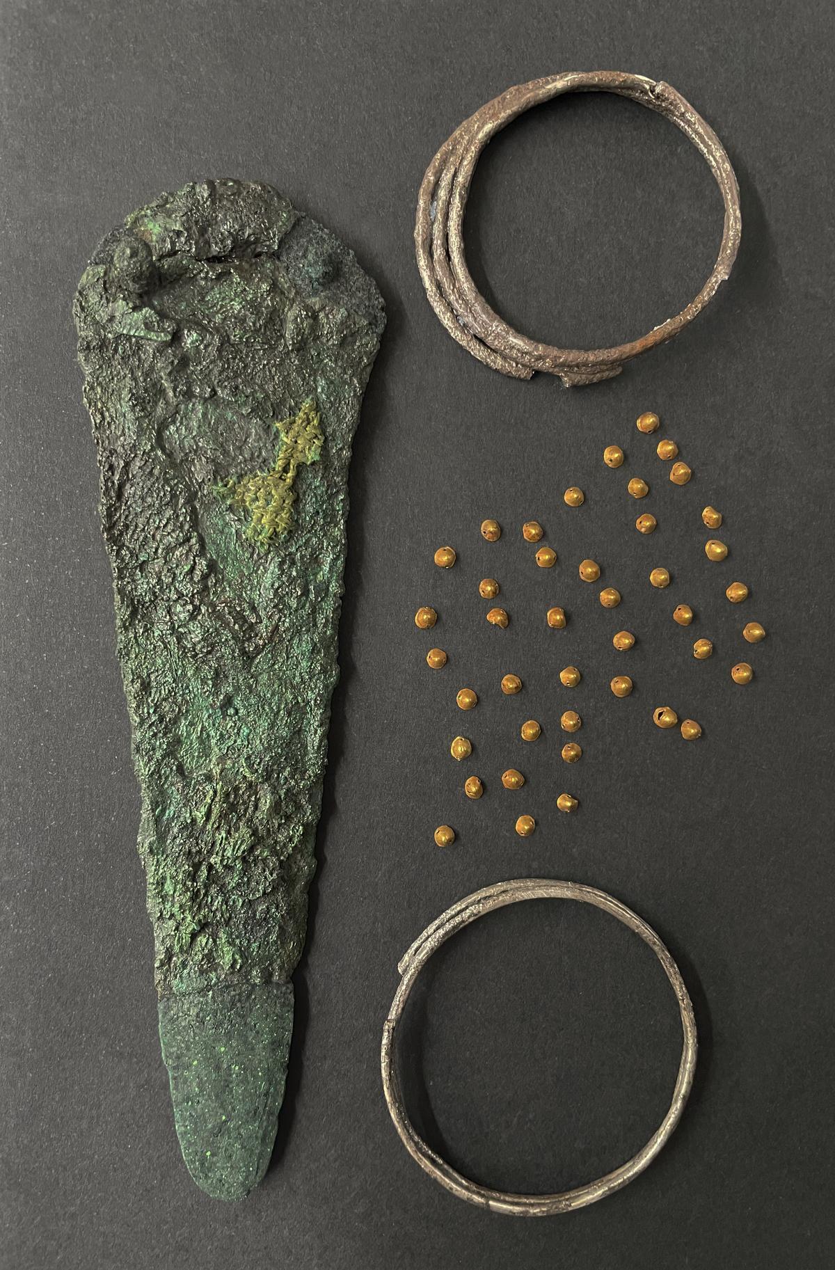 Conjunto de piezas del ajuar encontrado en Orihuela, con los pequeños conos de oro.