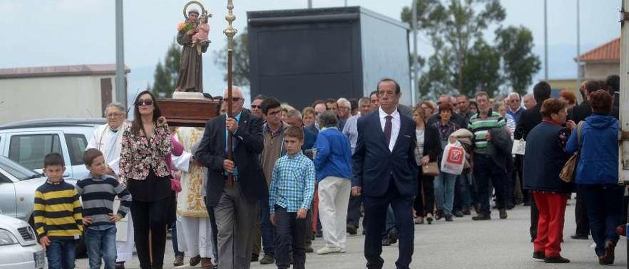 Sobre estas líneas, la procesión de San Antoniño do Pousadoiro. A la izquierda, los asistentes en el campo de la fiesta. // Noé Parga