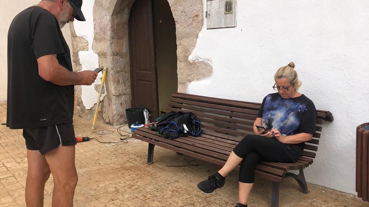 Dos personas intentan encontrar cobertura en sus móviles en la pedanía de Corachar, en la Pobla de Benifassà.