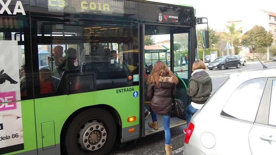 Unas usuarias suben a un autobús de Vitrasa en la parada de la Avenida de Redondela, en Chapela. // FdV