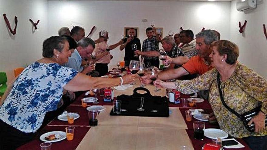 Un grupo de personas brinda con vino en un acto en Sanzoles.