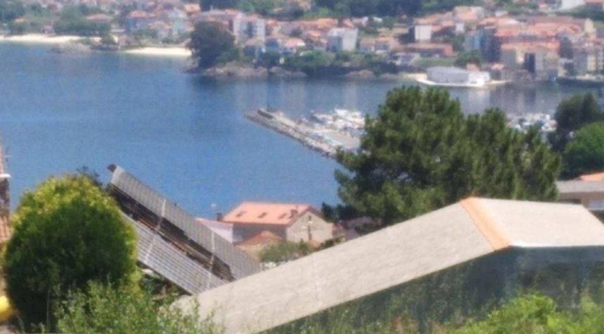 Dos agentes de Policía de Bueu intentan controlar el incendio de los contenedores junto al pabellón que provocó grandes llamas. | // FDV