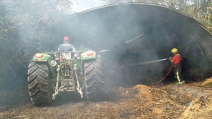 Mit einem Traktor mussten die Heuballen aus dem brennende Schuppen entfernt werden.