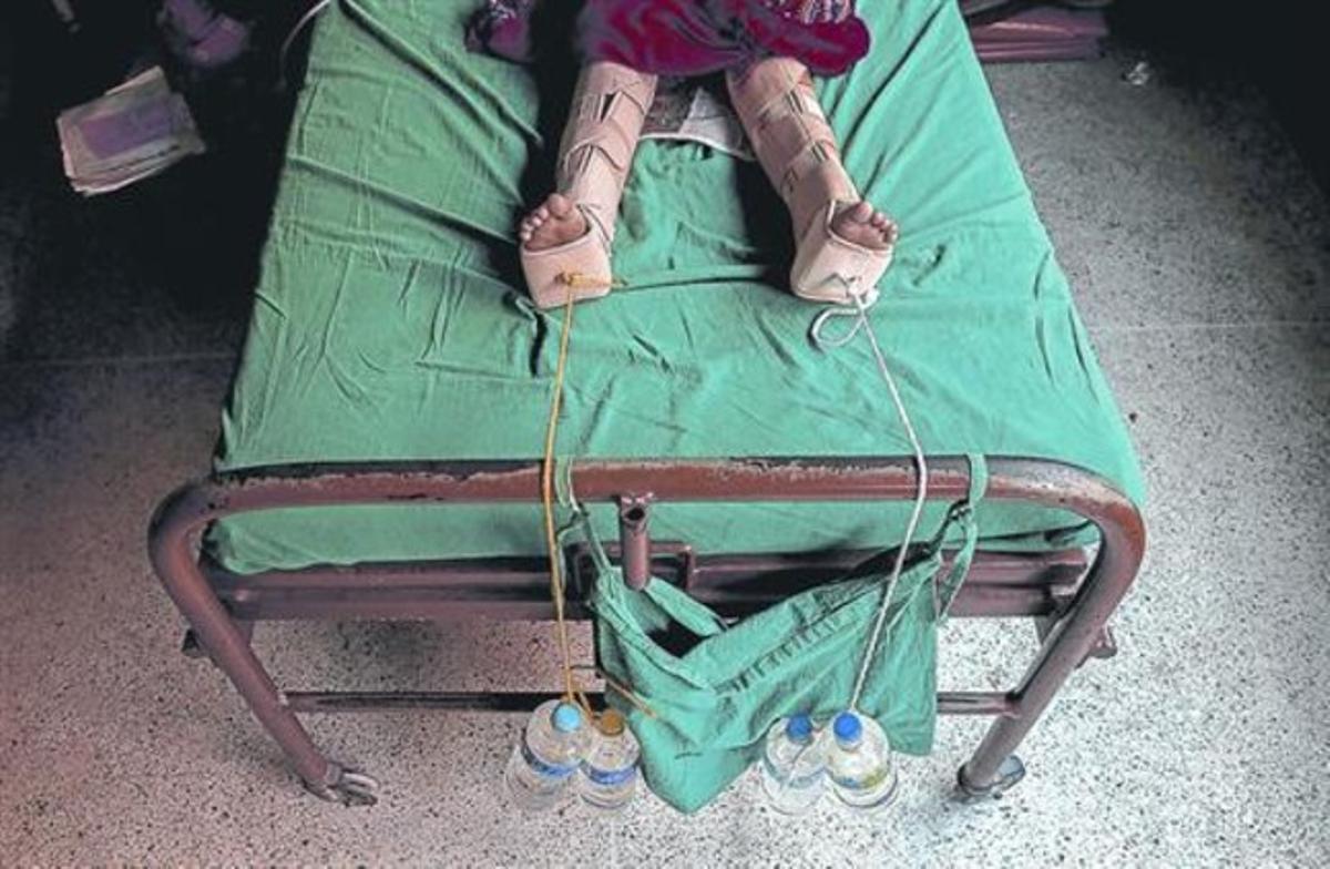 Ampolles d’aigua subjecten les cames d’un ferit enun hospital de Kàtmandu, ahir.